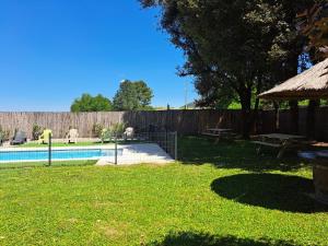 a backyard with a swimming pool and a fence at les petits chassezac in Grospierres