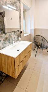 a bathroom with a sink and a chair at La Finestra sul Corso in Siracusa +18 photos