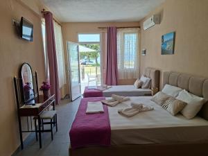 a hotel room with two beds and a balcony at Studio Lazaridi in Skala Rachoniou