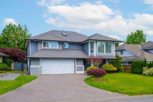 a blue house with a garage at Surrey Family Home w/ Patio & Garden – 3BR 2BA in Guildford