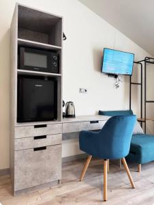 una camera da letto con scrivania, TV e sedia blu di Province Stone House Varna a Varna