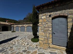 a stone building with a door and a tree at Province Stone House Varna in Varna City