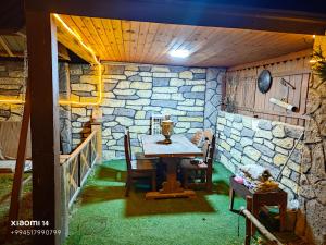 a room with a table and a stone wall at Quba A-Frame near Lake & Forest 1 in Quba