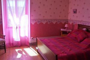 Habitación de color rosa con cama y ventana en La Grille Fleurie, chambre d'hôte chez l'habitant, en Arthonnay