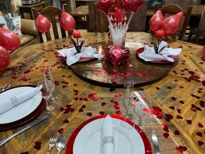 a table with red balloons and red roses on it at Sitio Renovo Juquitiba Hospedagens in Juquitiba +90 photos