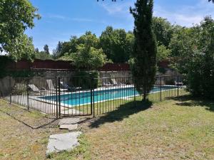 einen Zaun vor einem Pool in der Unterkunft Croassecorbeau Maison de Famille au pied du Ventoux in Malaucène