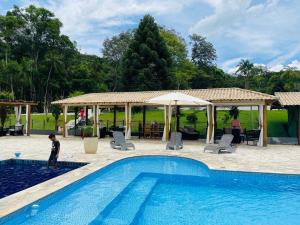 a boy standing in front of a swimming pool at Sitio Renovo Juquitiba Hospedagens in Juquitiba