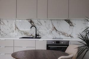 a kitchen with a marble counter top and a table at Blue alpine nest Komenda in Komenda