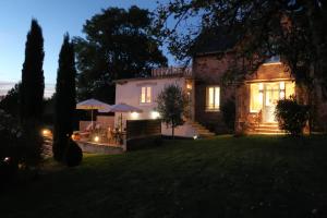 a house with a yard at night with lights at Maison La Chapelle Bellevue in Saint-Solve