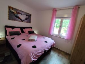 a bedroom with a bed with pink sheets and a window at apartman Goga with pool and jacuzzi in Labin +63 photos