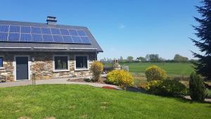 une maison avec des panneaux solaires sur le toit dans l'établissement Sixine House, à Ovifat