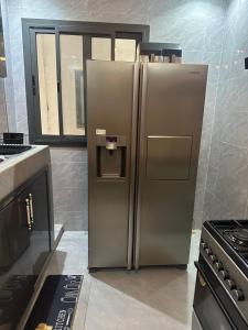 a stainless steel refrigerator in a kitchen at Cocon cozy magnifique Chambres d'hôtes in Dakar