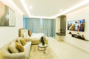 a living room with a couch and a bed and a television at Accra Luxury Apartments at Kass in Accra
