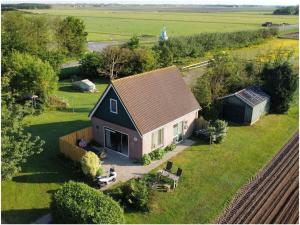 an aerial view of a small house in a field at Roeper Comfortable holiday residence in Koogerveld