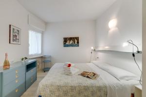 a white bedroom with a bed and a blue dresser at Residenza Lago D'Argento - Happy Rentals in Riva del Garda