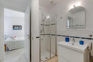 a white bathroom with a shower and a sink at Residenza Lago D'Argento - Happy Rentals in Riva del Garda