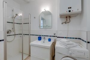 a white bathroom with a shower and a sink at Residenza Lago D'Argento - Happy Rentals in Riva del Garda
