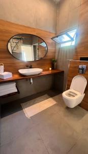 ein Badezimmer mit Toilette und Spiegel in der Unterkunft אירוח בגבעה in Giv‘at Shemuʼel