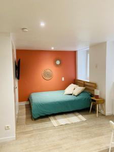 a bedroom with a bed with an orange wall at Terracotta, Appartement, Centre historique in Auch
