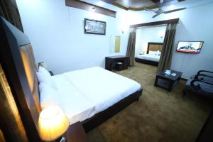 a hotel room with a bed and a mirror at Hotel The Shalimar in Lahore +26 photos