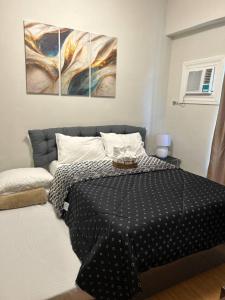 Lapu Lapu CityCozy & Convenient 1-Bedroom Condo 3 mins Away from the Airport的卧室配有一张墙上三幅画作的床 更多37张照片