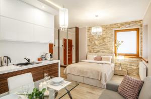 a kitchen and a bedroom with a bed and a table at TatryTop Zakopiańskie Tarasy Premium & SPA in Zakopane