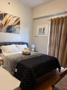 Lapu Lapu CityCozy & Convenient 1-Bedroom Condo 3 mins Away from the Airport的一间卧室配有一张带黑白毯子的床