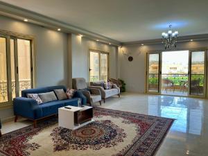 a living room with a blue couch and a rug at Luca Pyramids Inn in Cairo