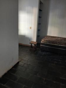 クイアバにあるPousadaのベッドとベンチのある空の部屋