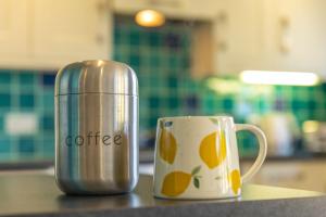 a coffee thermos sitting on a counter next to a cup at Ottery House in Westhampnett