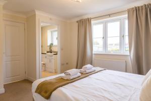 a bedroom with a bed with towels on it at Ottery House in Westhampnett