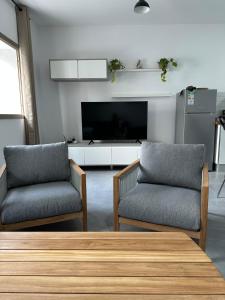 Una sala de estar con dos sillas y un televisor. en Im Herzen von Playa San Juan, en Playa de San Juan