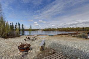 a picnic table and a bench next to a lake at Bass Farm Lake View Loft Cabin in Wasilla