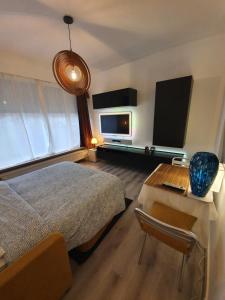 a bedroom with a bed and a desk with a laptop at Antwerp Hideaway, outside of low emission zone in Antwerp +9 photos