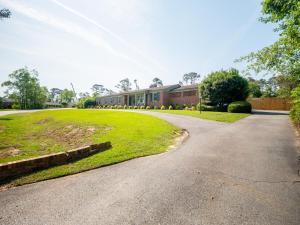 a driveway leading to a building with a grass yard at Luxury At Meadowbrook, Pool Home, Fire Pit, Fort in Valdosta