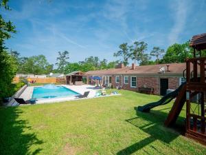 a backyard with a swimming pool and a house at Luxury At Meadowbrook, Pool Home, Fire Pit, Fort in Valdosta