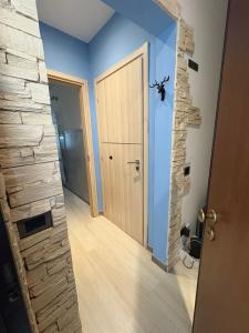 a hallway with a door and a stone wall at Maggioli3 in Alessandria