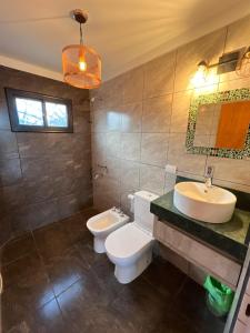 a bathroom with two toilets and a sink at Cabañas La vista in Cavalango