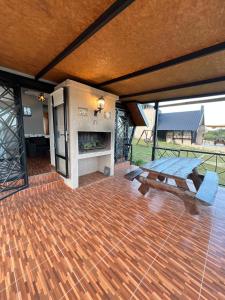 a patio with a picnic table and a fireplace at Cabañas La vista in Cavalango