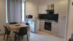 a kitchen with a table with chairs and a table and a tablecloth on it at Maggioli3 in Alessandria +1 photo