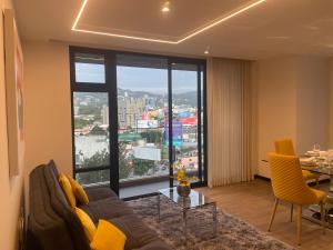 a living room with a couch and a large window at Lujoso Apto 2 habitaciones cerca Oakland Place Zona 10 GT in La Aurora