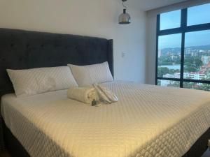 a bed with a stuffed animal on top of it at Lujoso Apto 2 habitaciones cerca Oakland Place Zona 10 GT in La Aurora +71 photos