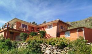 a large house with a hill in the background at Amantaní Elisa's lodge Puno in Puno