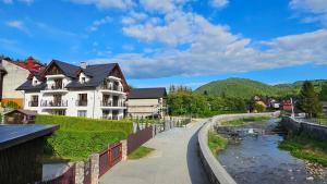 ein Haus neben einem Fluss in einer Stadt in der Unterkunft Willa Zacisze Szczawnica 25m2 Ip in Szczawnica