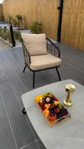 a plate of fruit on a table next to a chair at cozy rv in Falaj al Mu‘allá