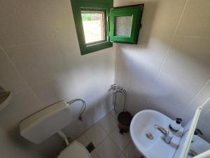 a bathroom with a toilet and a sink and a window at Klimataria Studios Sithonia in Skála Sikiás