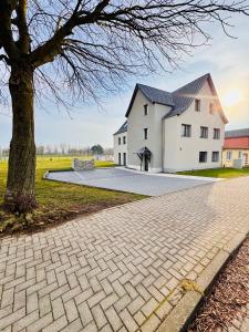 a house with a tree and a brick driveway at CLUBHAUS 6 - geräumige Ferienwohnung mit 4 Schlafzimmern & 2 Bädern in Worbis
