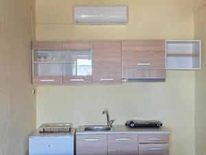 a kitchen with wooden cabinets and a sink at Klimataria Studios Sithonia in Skála Sikiás +19 photos
