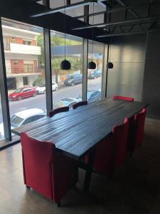 a wooden table in a room with red chairs at Royal Park, Category Apartment, 200m del Mar in Mar del Plata +49 photos