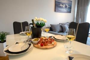 Una mesa con un plato de comida y copas de vino. en Vanilla apartment, en Šibenik